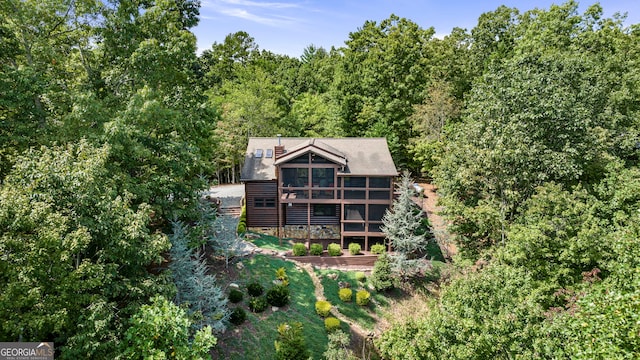 rear view of property featuring a sunroom and a wooden deck