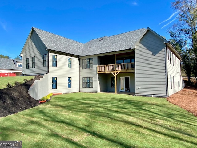 back of property with a lawn and a balcony