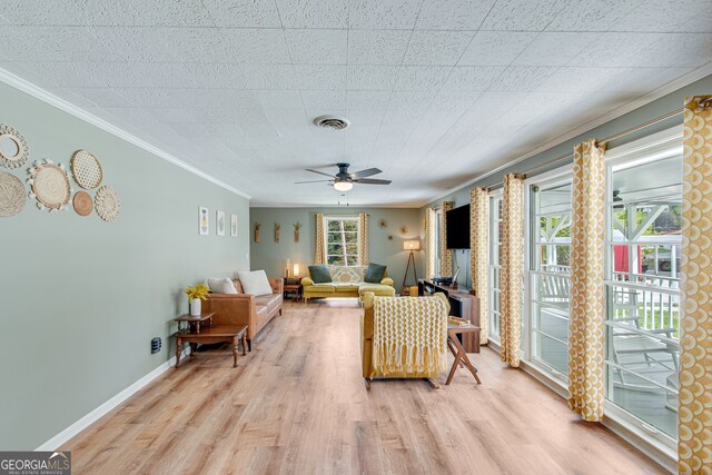 living room with light wood-type flooring, ceiling fan, and ornamental molding