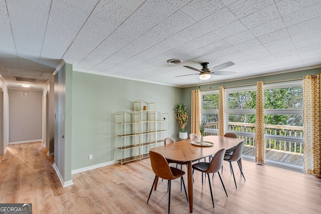 dining space with ceiling fan, ornamental molding, and light hardwood / wood-style flooring