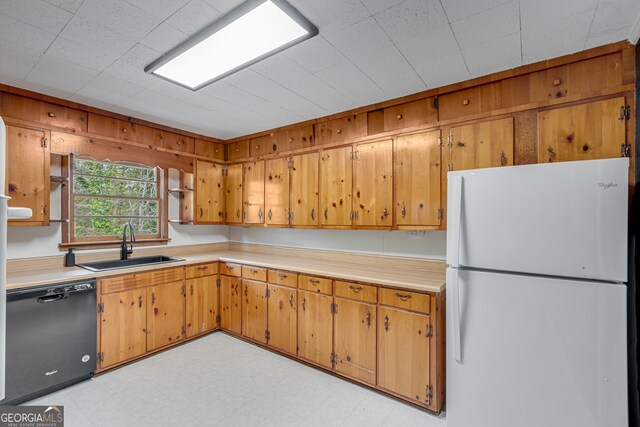 kitchen with dishwasher, white fridge, and sink