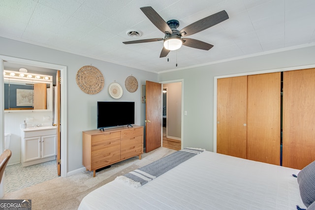 bedroom with ensuite bath, ceiling fan, ornamental molding, light colored carpet, and a closet