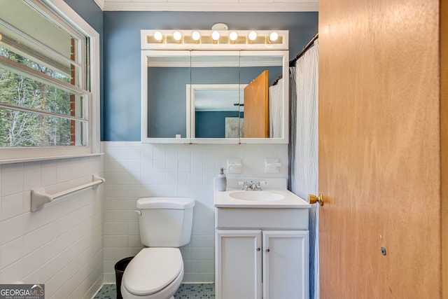 bathroom with curtained shower, tile patterned flooring, toilet, vanity, and tile walls