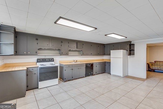 kitchen featuring gray cabinetry, white appliances, sink, and light tile patterned floors