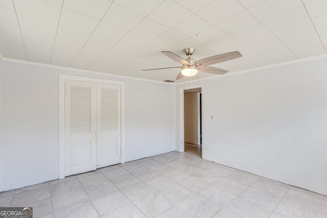 unfurnished bedroom featuring ceiling fan, crown molding, and a closet