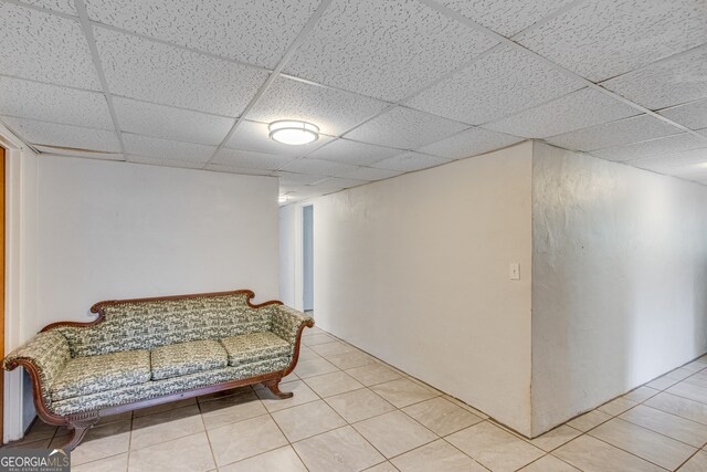 sitting room with a drop ceiling and light tile patterned floors