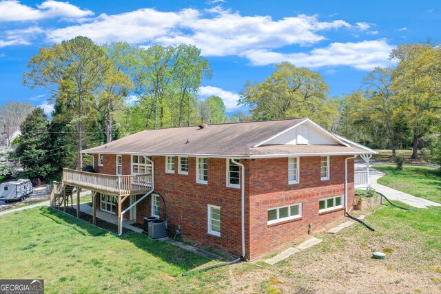 view of property exterior featuring central air condition unit, a wooden deck, and a lawn