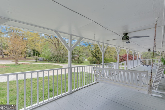 deck featuring covered porch, a yard, and ceiling fan