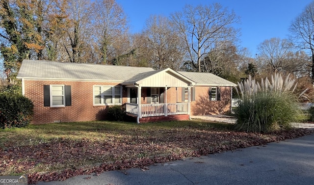 ranch-style home with covered porch and a front lawn