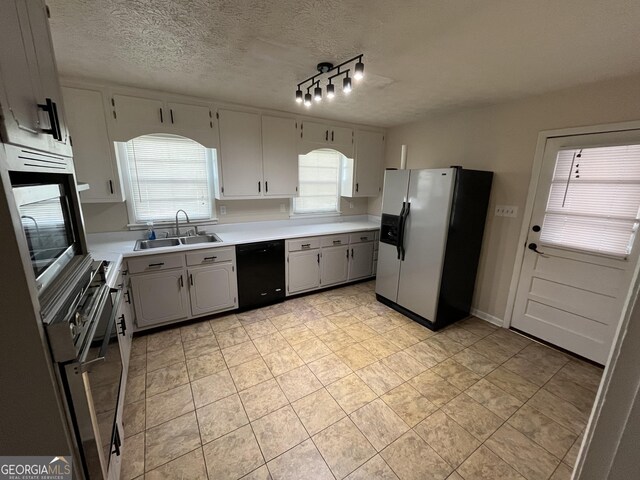 kitchen featuring a textured ceiling, plenty of natural light, sink, and appliances with stainless steel finishes