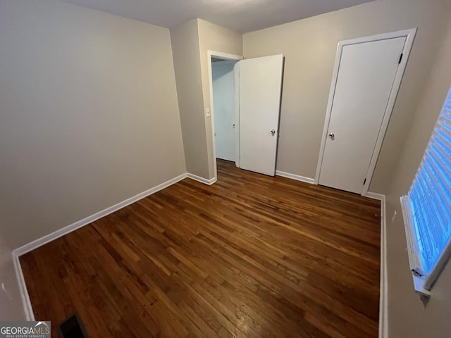 unfurnished bedroom with dark hardwood / wood-style floors