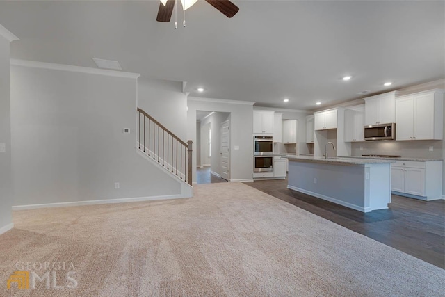 kitchen featuring appliances with stainless steel finishes, sink, an island with sink, and white cabinetry