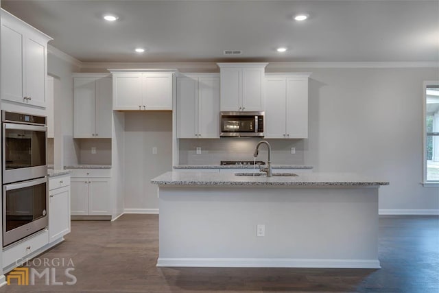 kitchen featuring a center island with sink, white cabinetry, stainless steel appliances, and sink