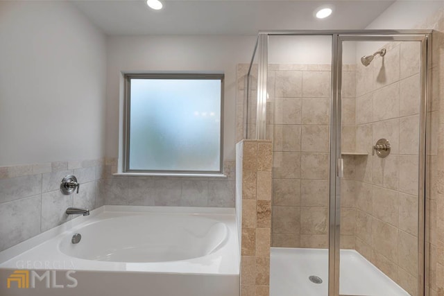 bathroom featuring shower with separate bathtub