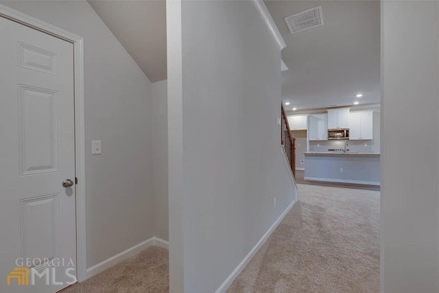 hallway featuring light carpet