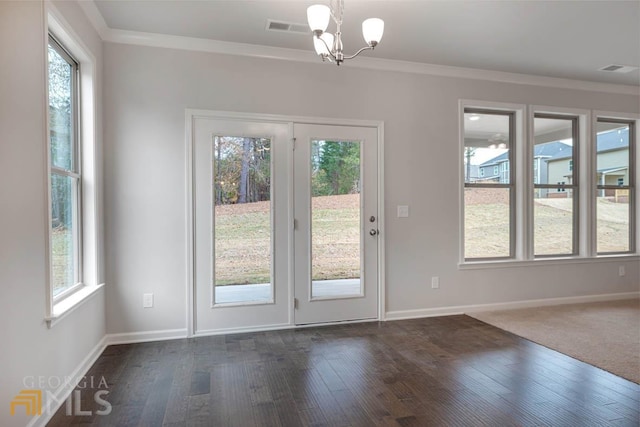 doorway featuring an inviting chandelier, dark hardwood / wood-style flooring, and ornamental molding