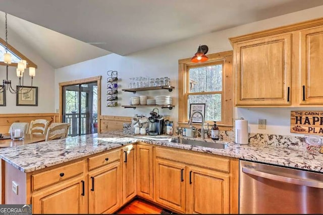 kitchen with hanging light fixtures, light stone counters, sink, and stainless steel dishwasher