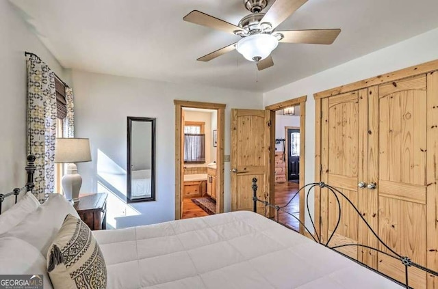 bedroom with connected bathroom, ceiling fan, and dark hardwood / wood-style flooring