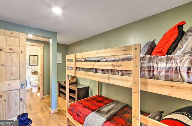 bedroom featuring ensuite bathroom and light hardwood / wood-style floors