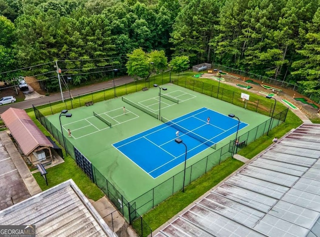 view of tennis court with a yard