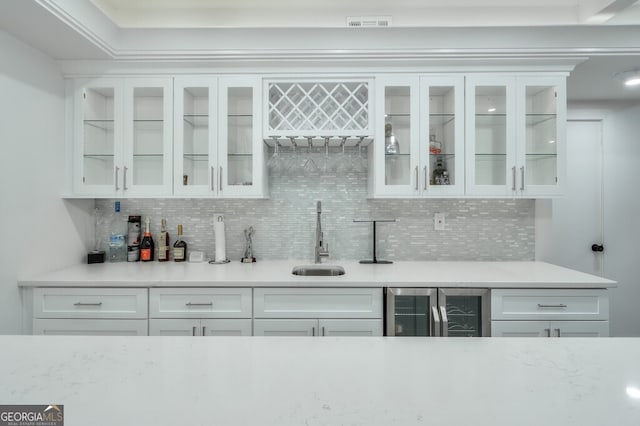 bar featuring white cabinets, decorative backsplash, sink, and wine cooler