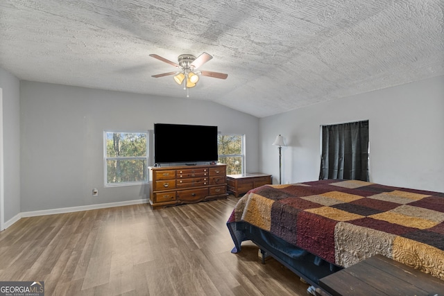 bedroom featuring a textured ceiling, ceiling fan, hardwood / wood-style floors, and lofted ceiling