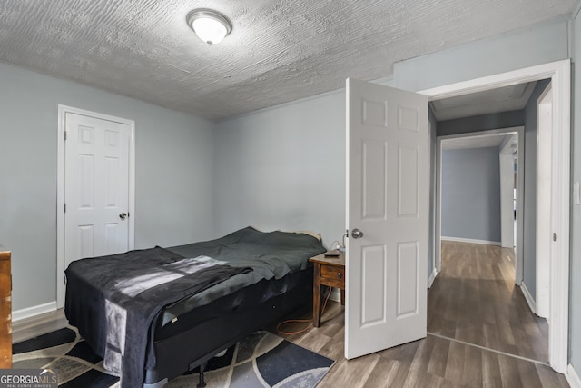 bedroom featuring hardwood / wood-style flooring and a textured ceiling