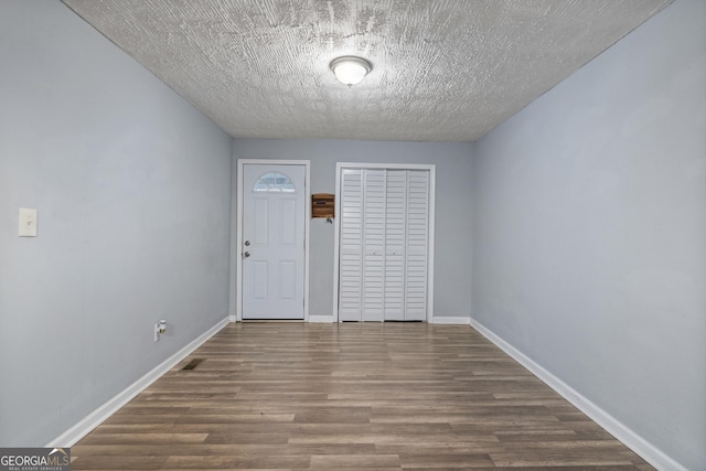 entryway with wood-type flooring and a textured ceiling