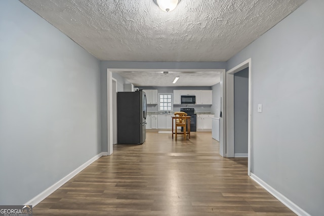 hall featuring dark hardwood / wood-style floors and a textured ceiling