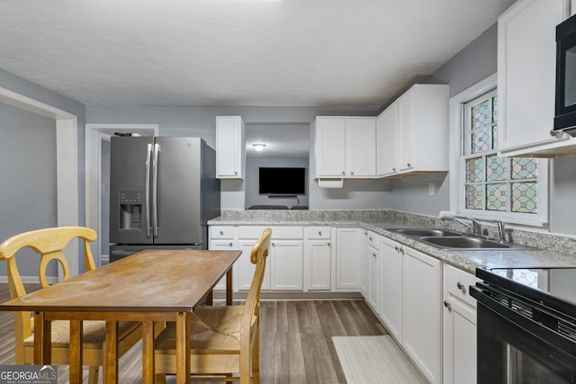 kitchen featuring white cabinets, sink, stainless steel refrigerator with ice dispenser, and hardwood / wood-style floors