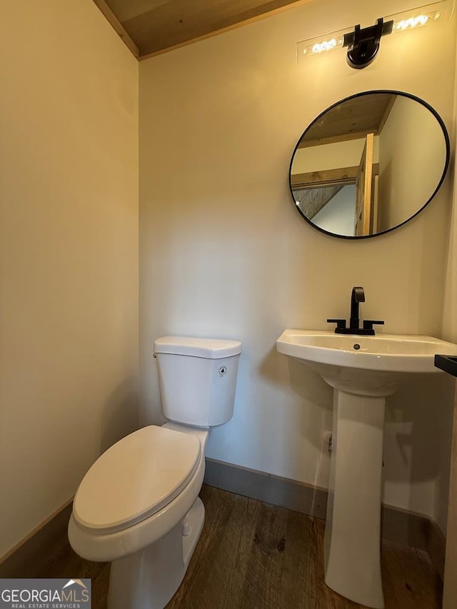 bathroom featuring wood-type flooring and toilet