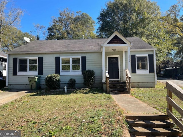 bungalow-style home with a front lawn