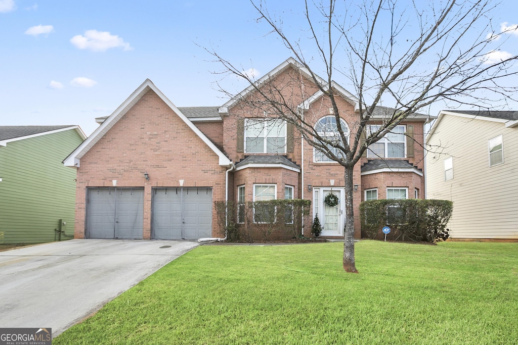 view of property featuring a garage and a front lawn