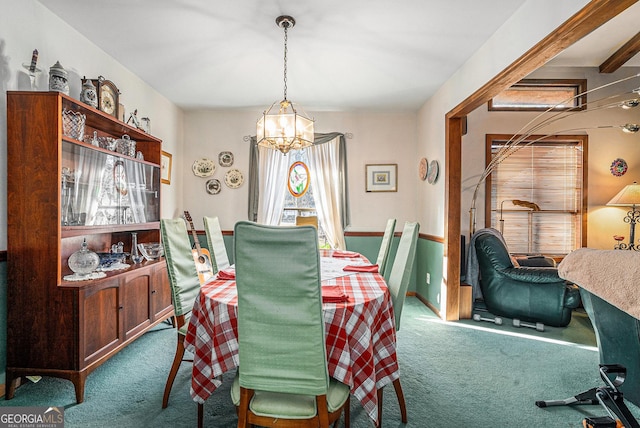 carpeted dining room with beam ceiling and a chandelier