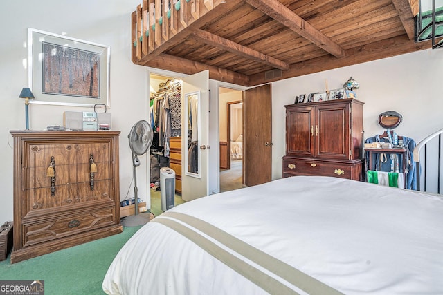 bedroom with wooden ceiling, a walk in closet, beam ceiling, carpet floors, and a closet