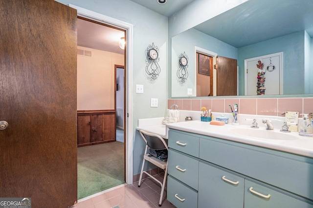 bathroom with tasteful backsplash, tile patterned flooring, and vanity