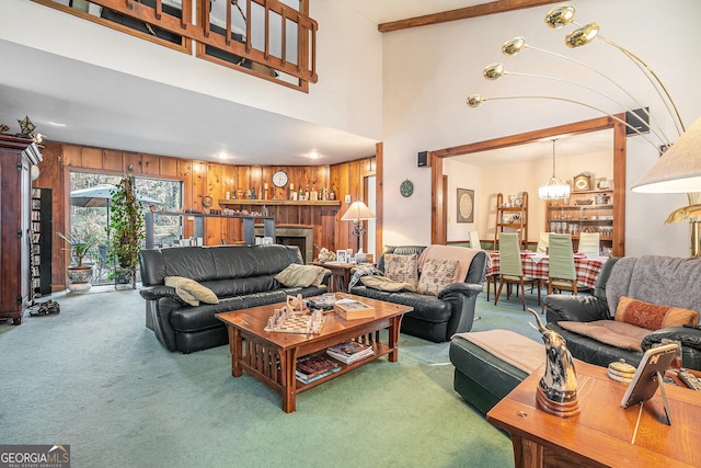 carpeted living room with beamed ceiling, a notable chandelier, wood walls, and a towering ceiling