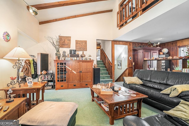 carpeted living room featuring beamed ceiling, high vaulted ceiling, wooden walls, and a notable chandelier