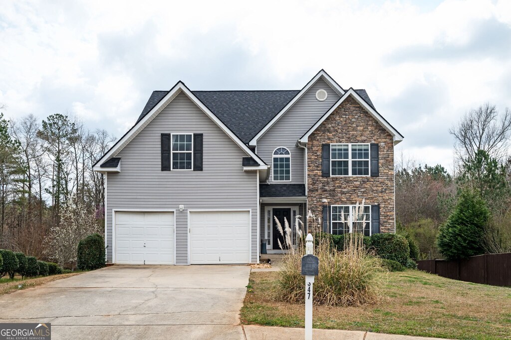 front facade featuring a garage and a front lawn