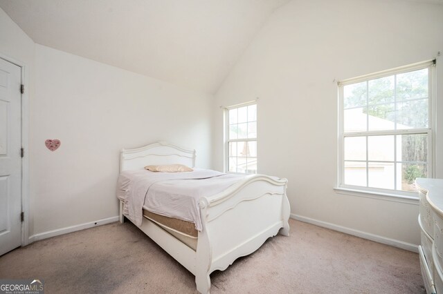 bedroom featuring light carpet, multiple windows, baseboards, and vaulted ceiling