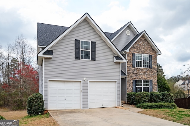 traditional home featuring stone siding, driveway, a garage, and roof with shingles