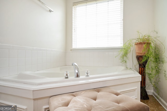 full bathroom featuring baseboards and a garden tub