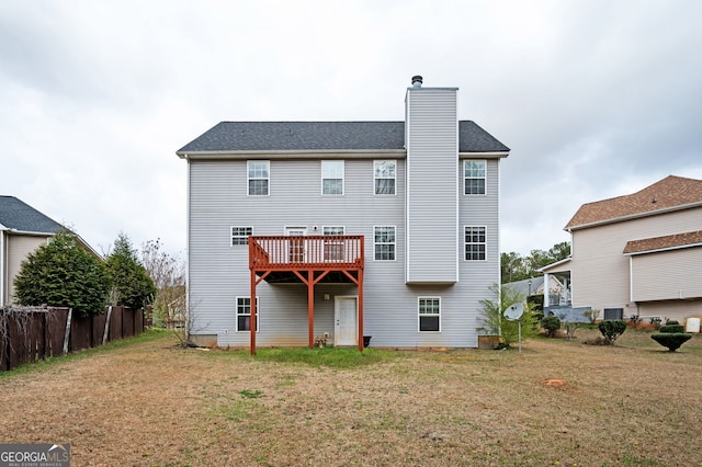 rear view of house with a chimney and a yard