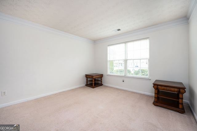 carpeted spare room featuring visible vents, a textured ceiling, crown molding, and baseboards