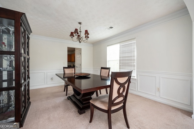 dining space with visible vents, light carpet, a textured ceiling, crown molding, and a chandelier