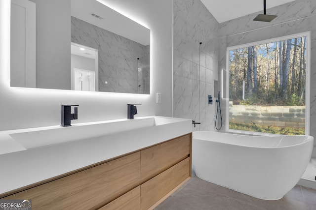 bathroom featuring separate shower and tub, vanity, and tile walls