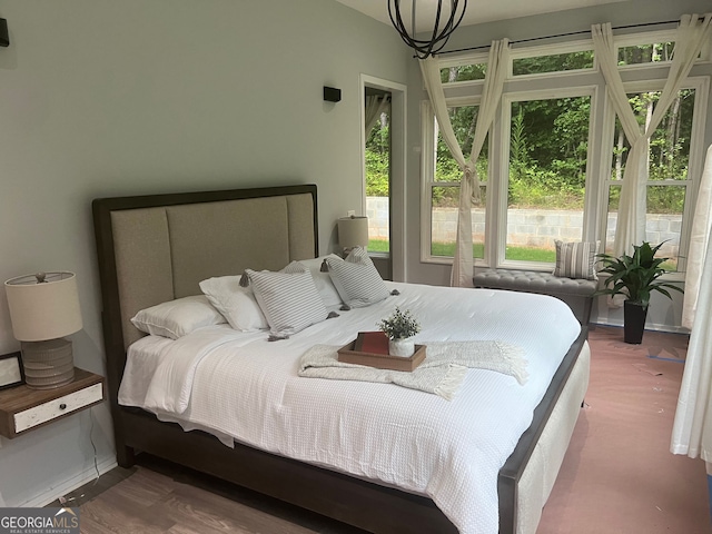 bedroom with wood-type flooring and multiple windows