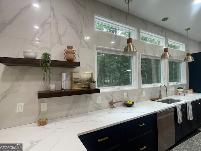 kitchen with light stone countertops, stainless steel dishwasher, hanging light fixtures, and sink