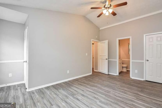 unfurnished bedroom with wood-type flooring, ensuite bathroom, vaulted ceiling, and ceiling fan