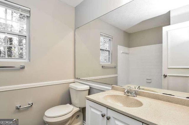 bathroom with plenty of natural light, vanity, and toilet